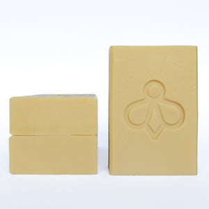 Three Baby Bee Soaps - One standing upright, while two are stacked neatly next to it. Experience the gentle touch of our nurturing and natural soap, perfect for tender care. Ideal for little ones and the whole family.