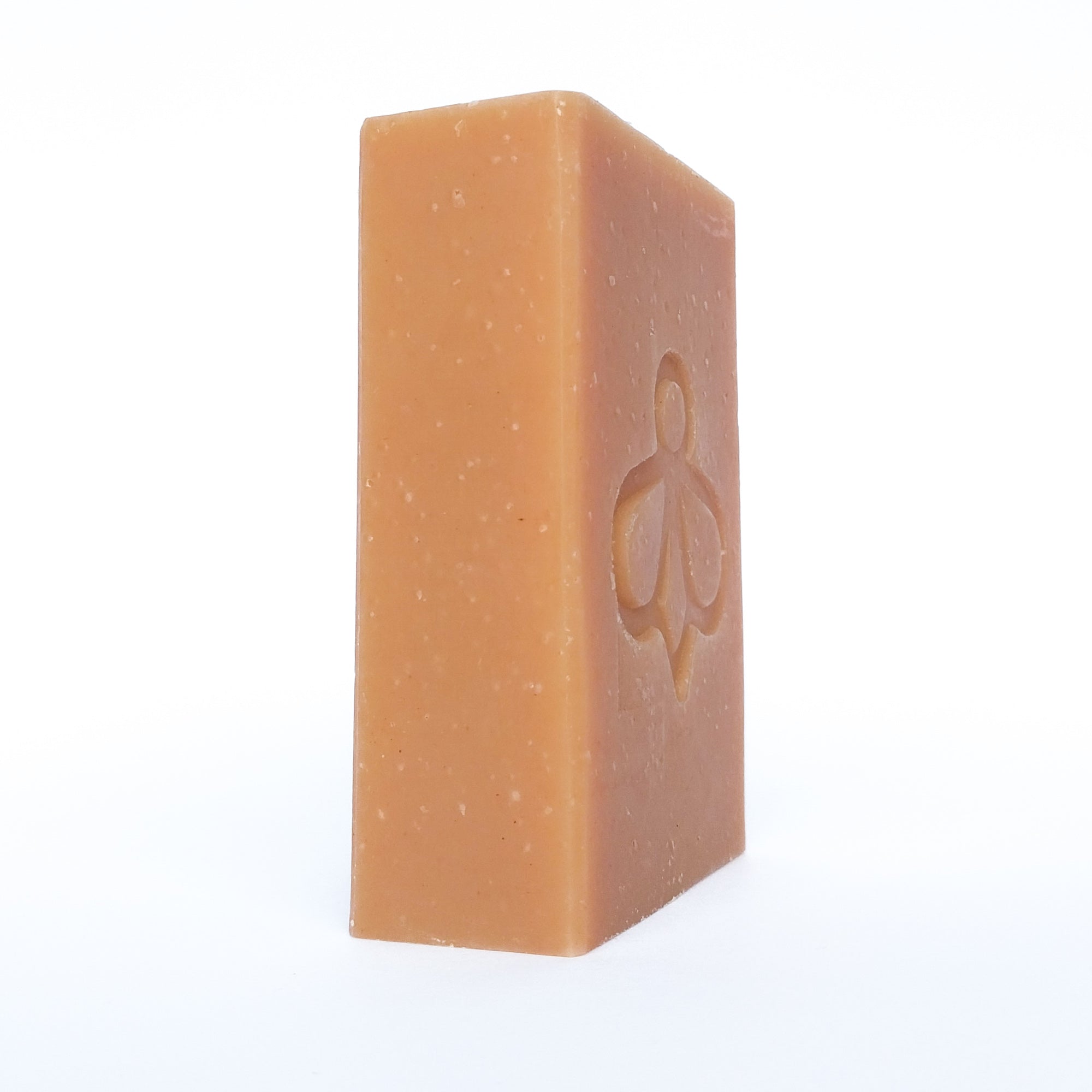 Honey Rose Soap on Angle - Featuring our bee logo imprint on a rose-coloured bar, displayed at an angle against a clean white background.