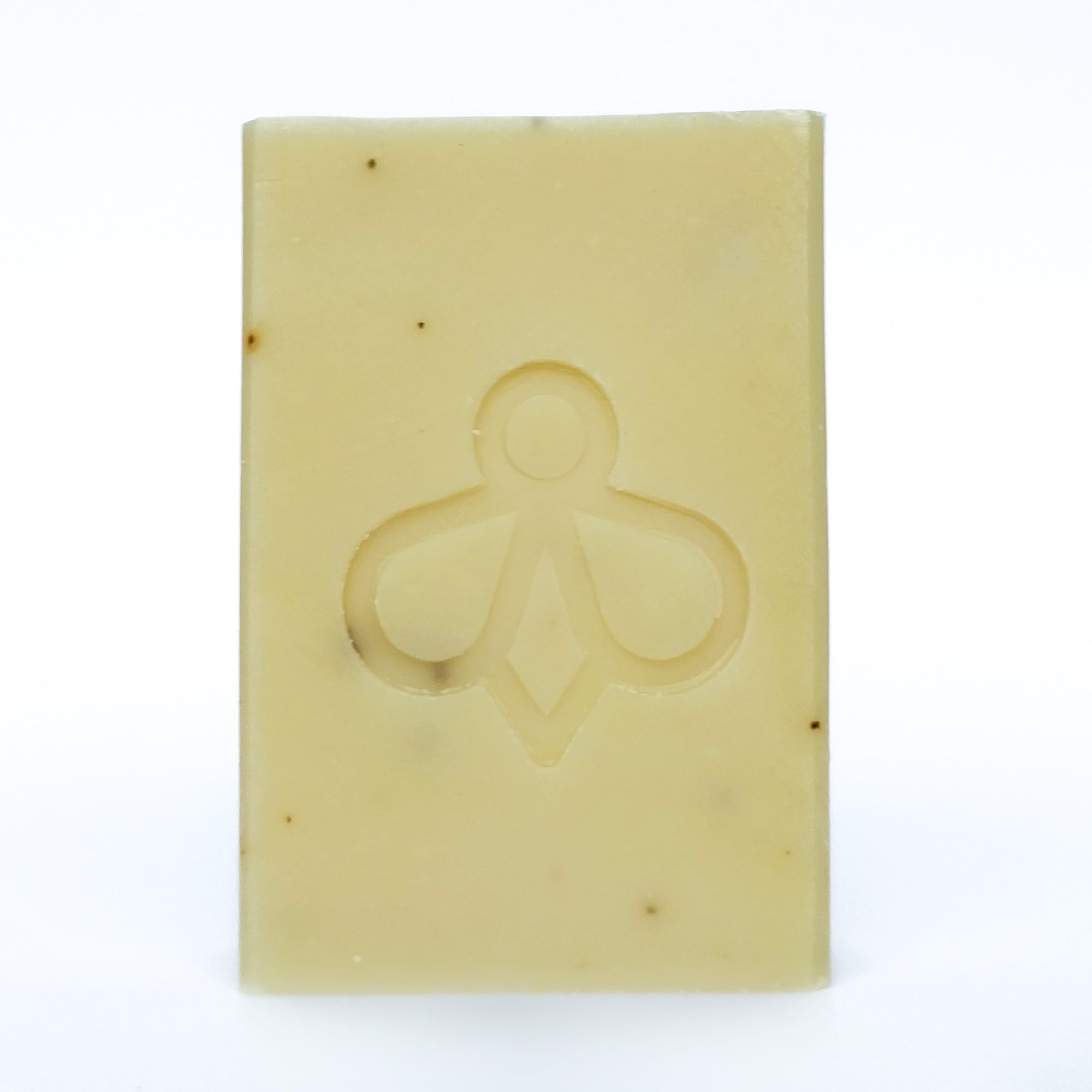Lavender and Aloe Vera Soap - A soft white bar with black speckles, featuring our bee imprint, displayed against a clean white background. Immerse yourself in the soothing aroma of lavender.