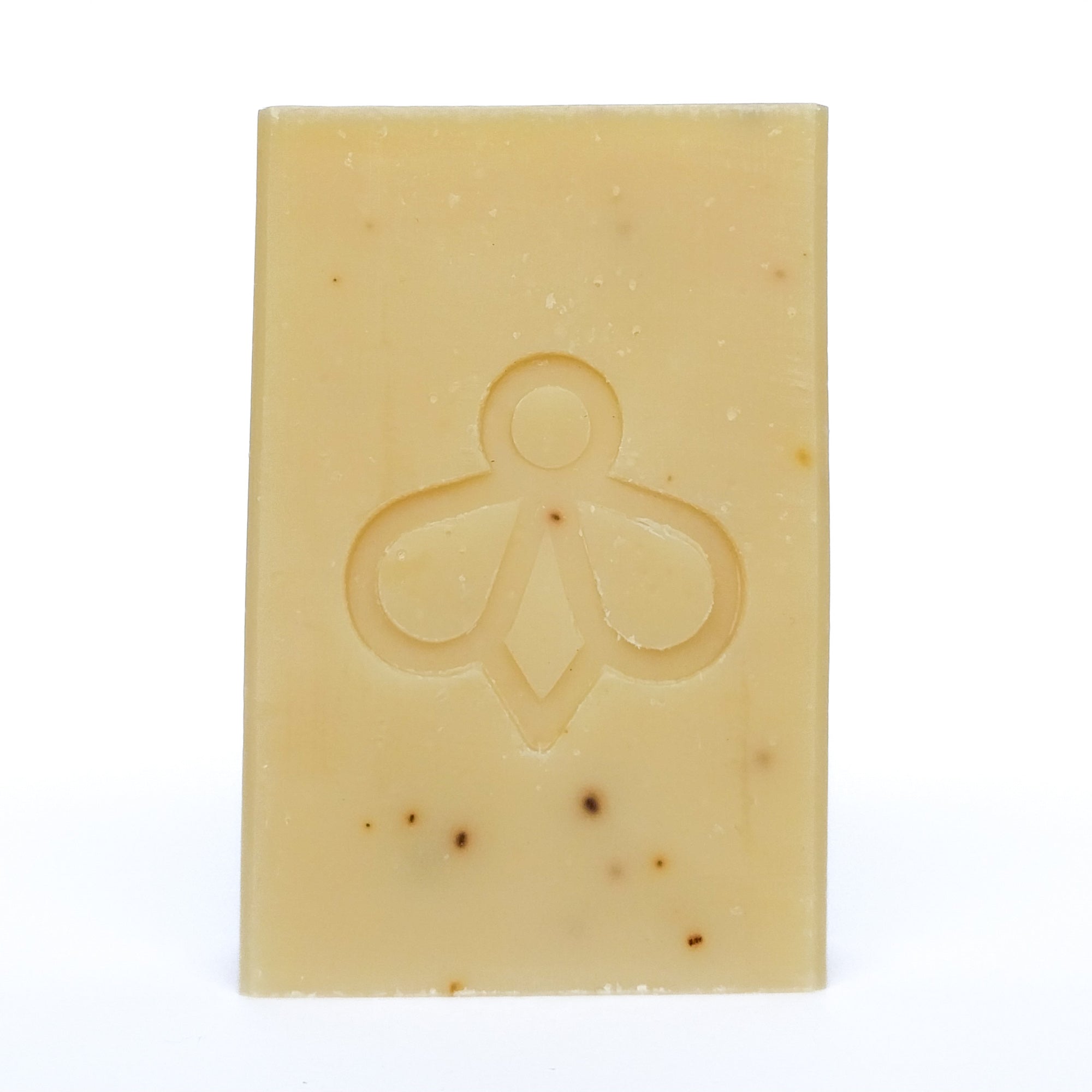 Lavender and Goat’s Milk Soap - A creamy-coloured bar with black speckles, featuring our bee imprint, displayed against a clean white background. Immerse yourself in the soothing blend of lavender and goat’s milk for a gentle and nourishing bathing experience.