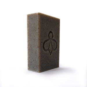 Worker Bee Scrubby Soap - Angled view of the soap with our bee logo imprint, showcasing its charcoal colour on a white background.