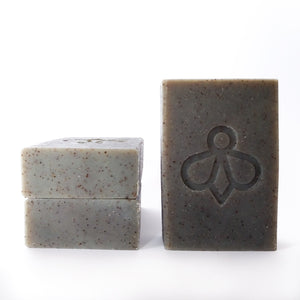 Worker Bee Scrubby Soap Trio - One soap stands upright while two others are neatly stacked beside it. Experience the tough cleaning power of our Worker Bee Scrubby Soap, specially crafted to tackle tough grease and grime. Ideal for heavy-duty cleaning tasks and perfect for busy bees in the garden.