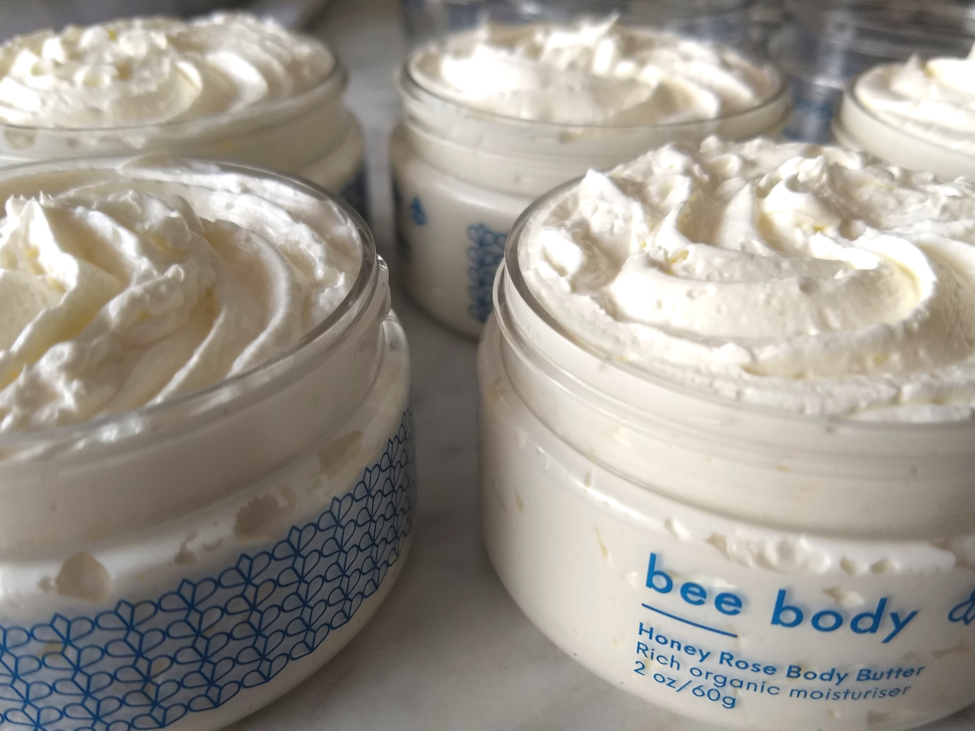 Honey Rose Body Butter: Multiple jars of creamy goodness, with lids removed, revealing the smooth and velvety texture of each delectable blend.